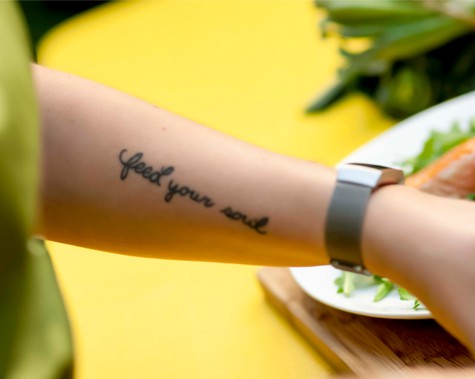 Arm tattoo reading "feed your soul."